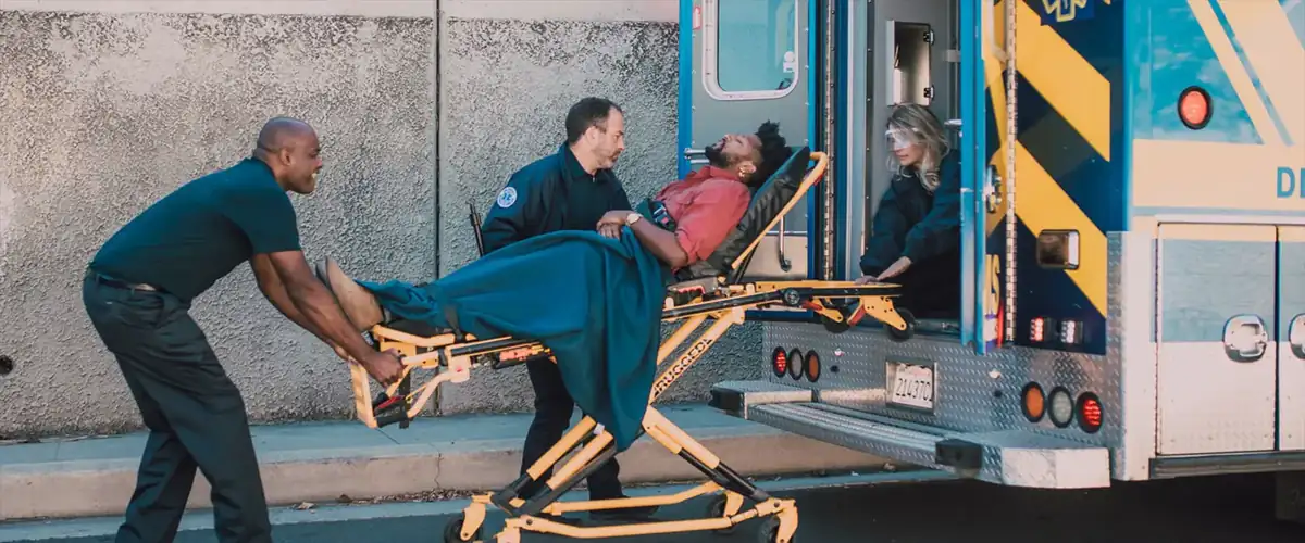 Patient transfer on a stretcher into an ambulance